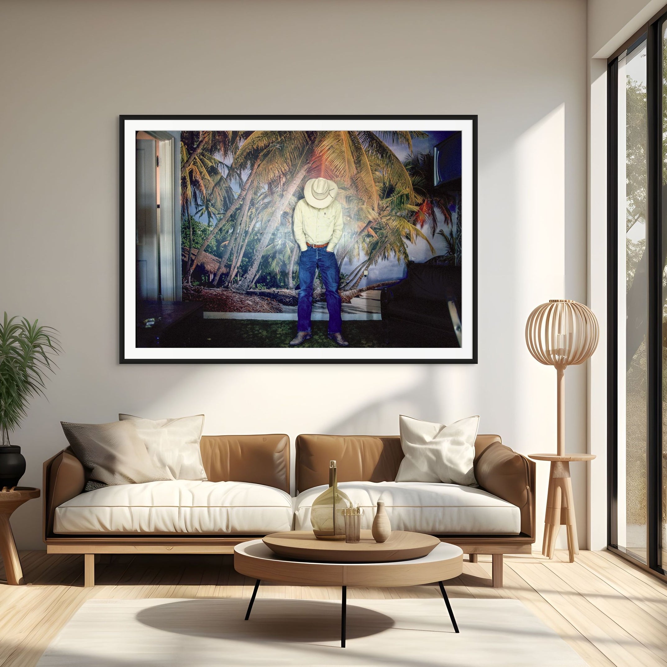 Modern living room with a painting of a person in a hat and sunglasses on a wall.