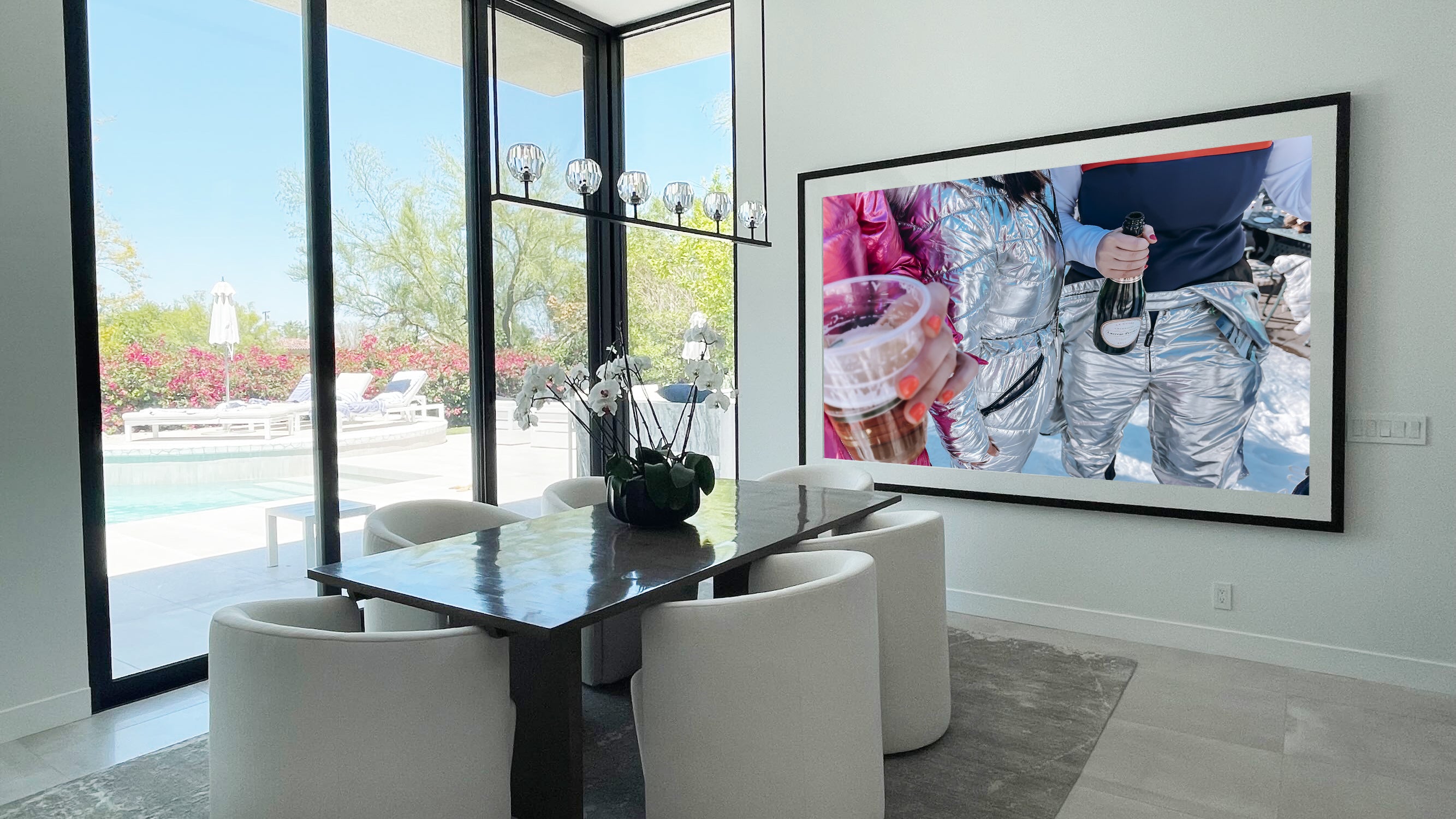 Modern dining room with a large TV displaying a sports event.