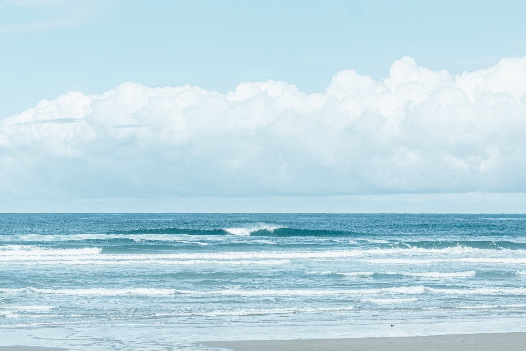 Beach scene with ocean waves and a clear sky