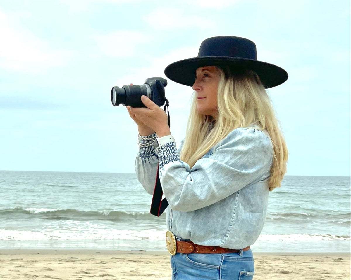 Woman taking a photo on a beach with a camera