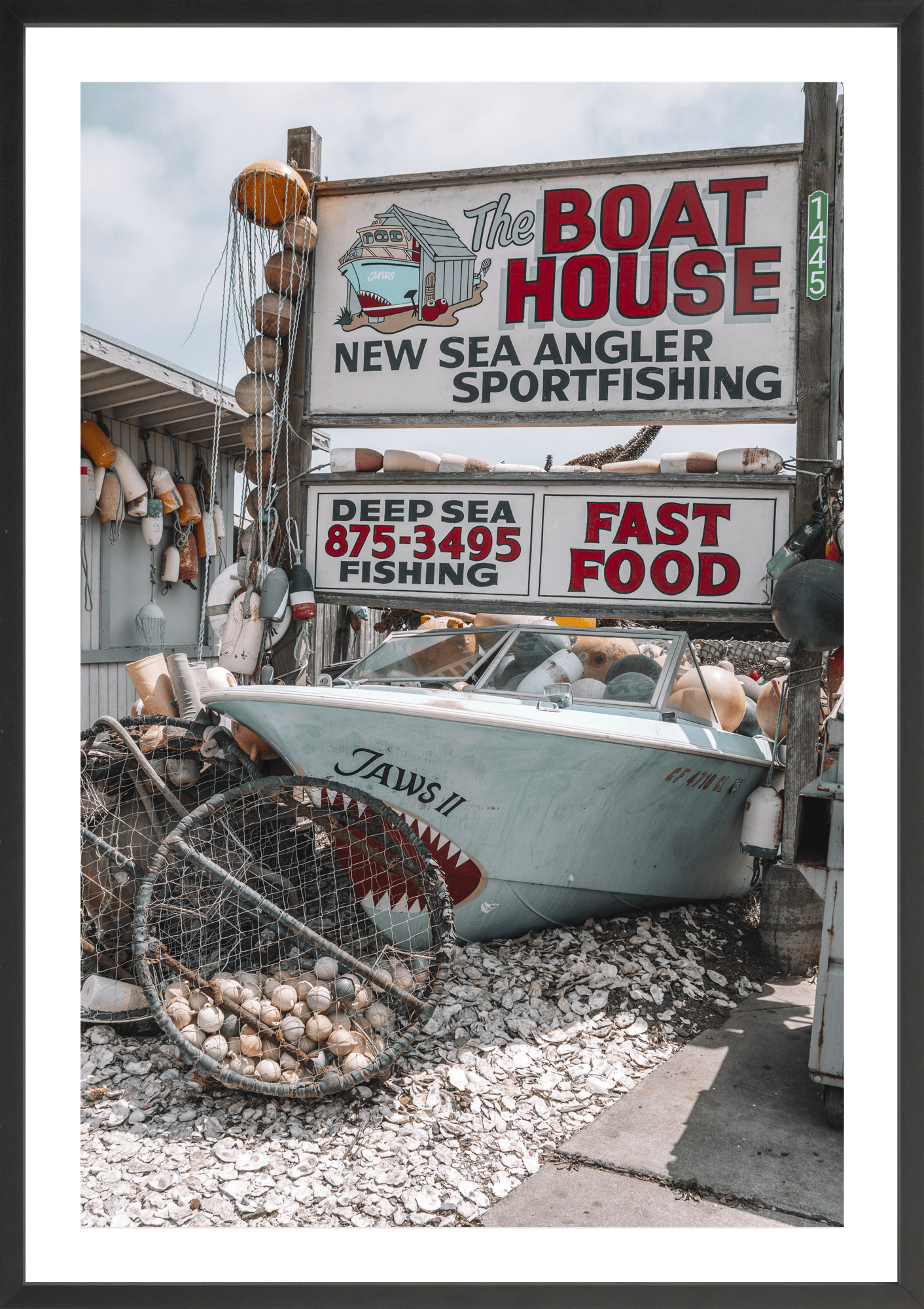 Coastal classic brimming with vintage memorabilia, Boat House, modern fine art print with retro seaside charm. Black frame.