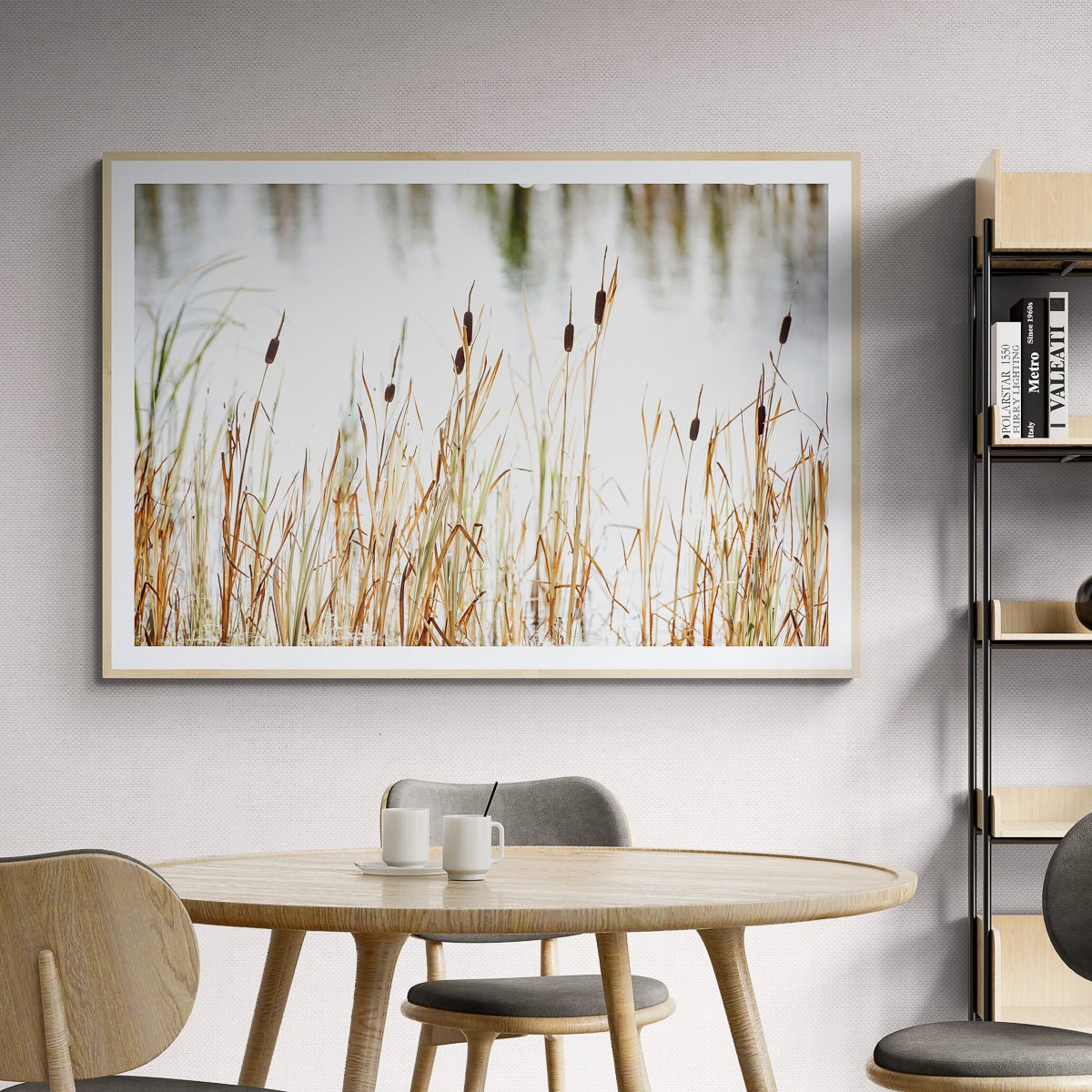 Cattails, Jackson Hole, Wyoming fine art print in a natural wood frame above a round wooden dining table, by Jules Frazier