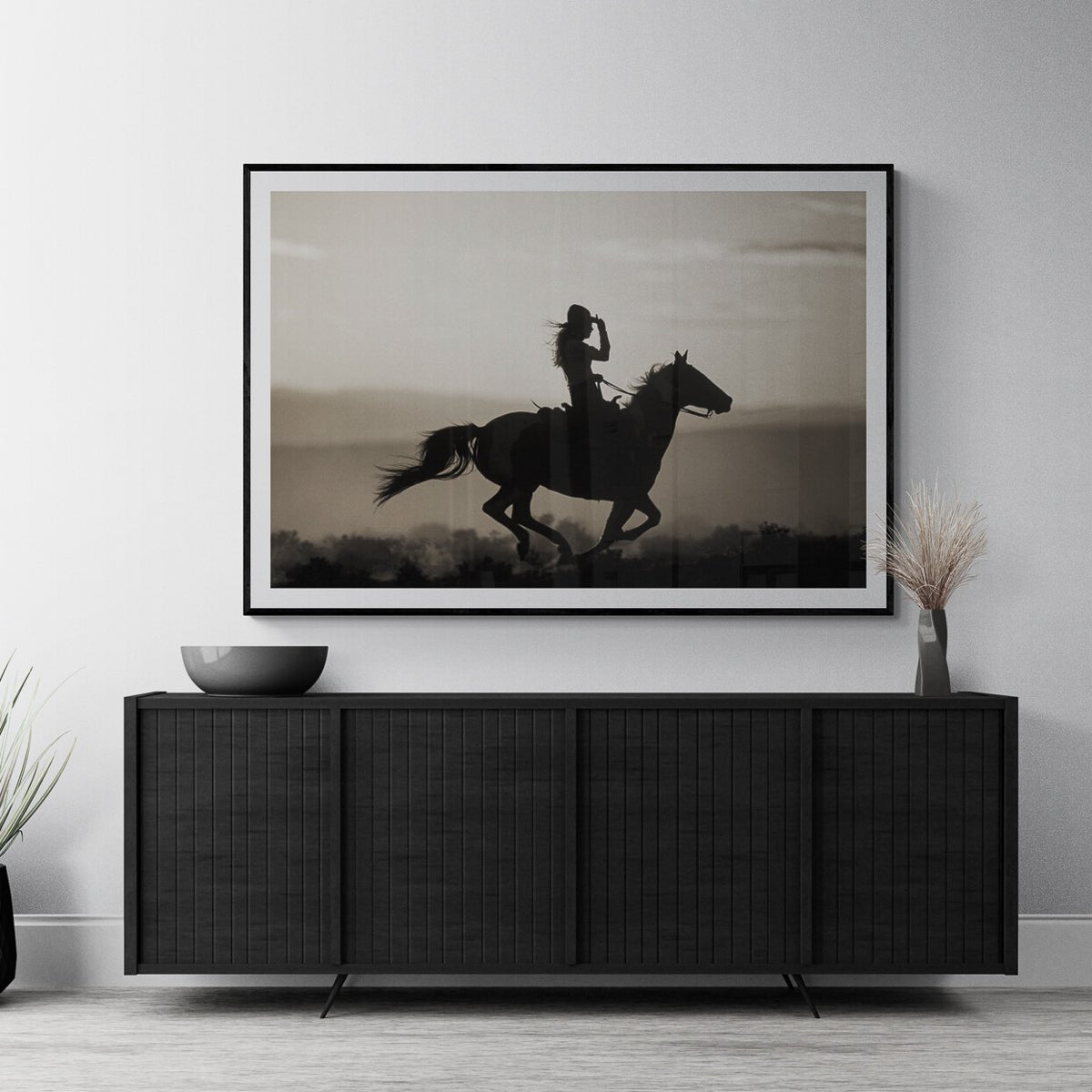 Girl on Horseback fine art print in a black frame above a black credenza, by Jules Frazier