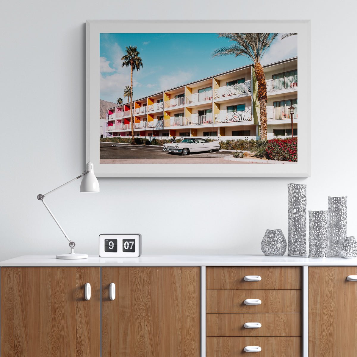 Guitars and Cadillacs, Palm Springs, California fine art print in a white frame above a credenza, by Jules Frazier