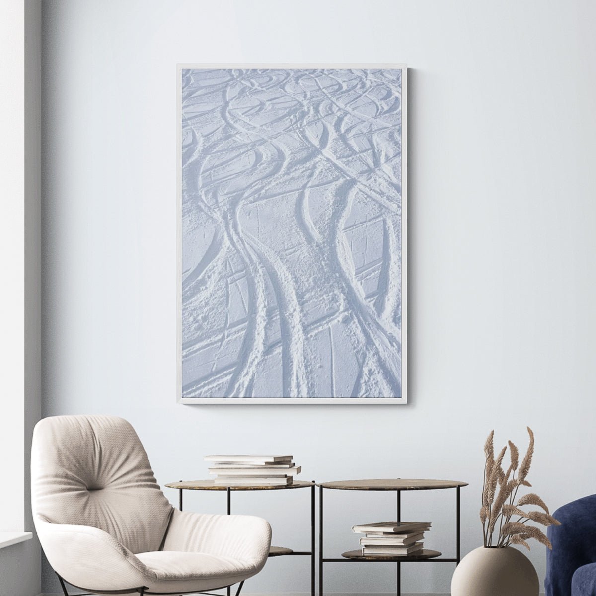 Ski Tracks fine art print in a white frame above side tables, by Jules Frazier