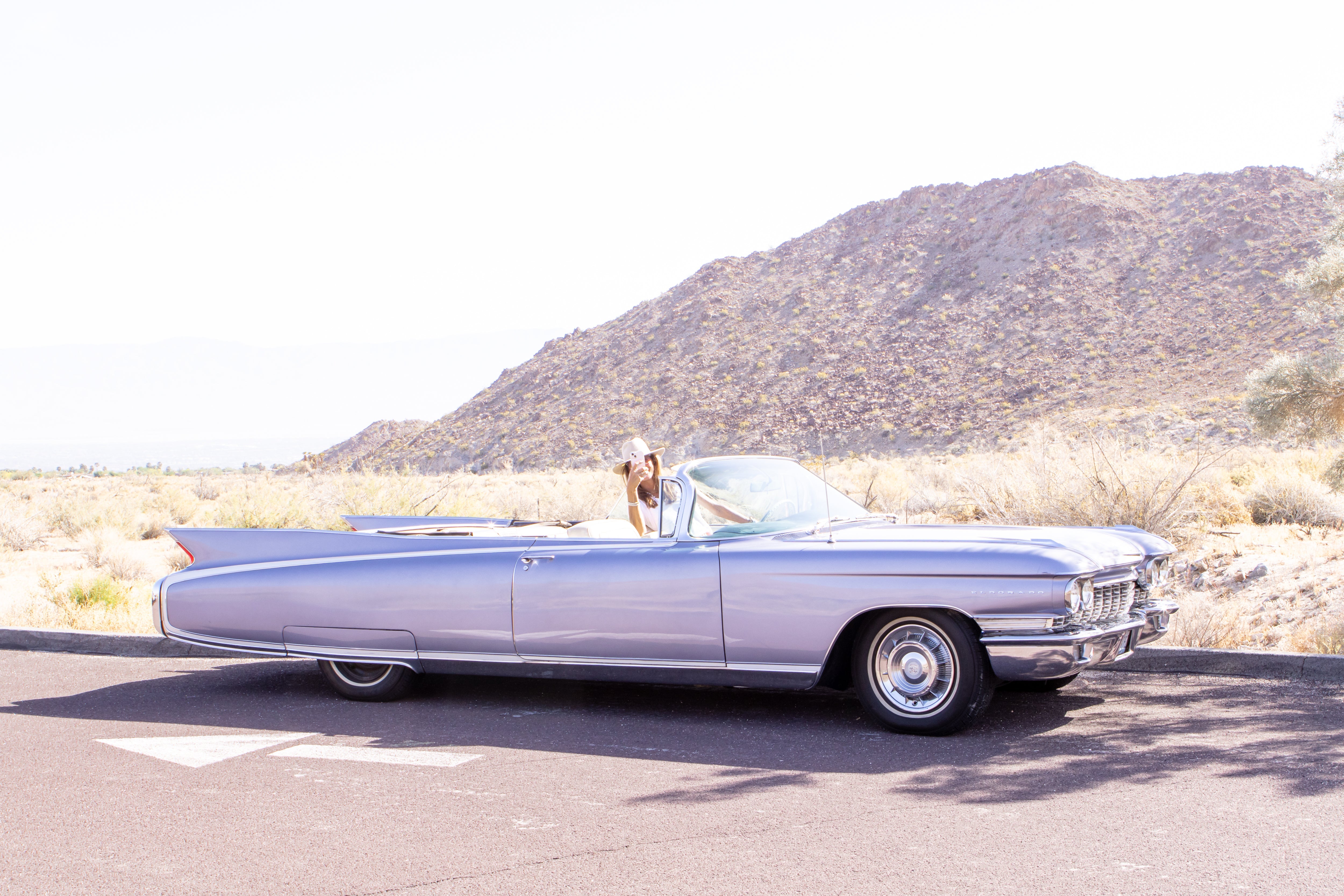 Girl in Cadillac taking photos