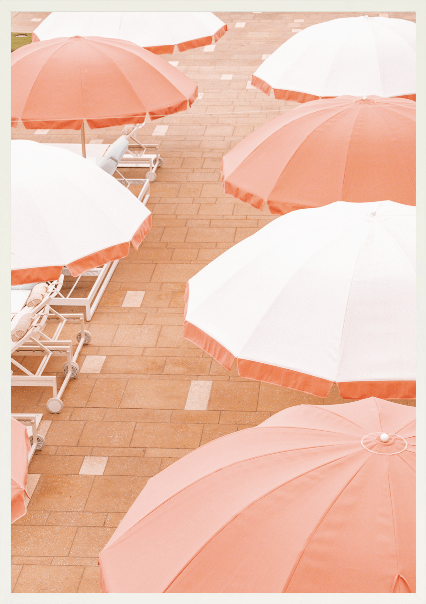 Layers of vivid coral and sun-washed umbrellas create a playful pattern of classic beach club style, white frame.