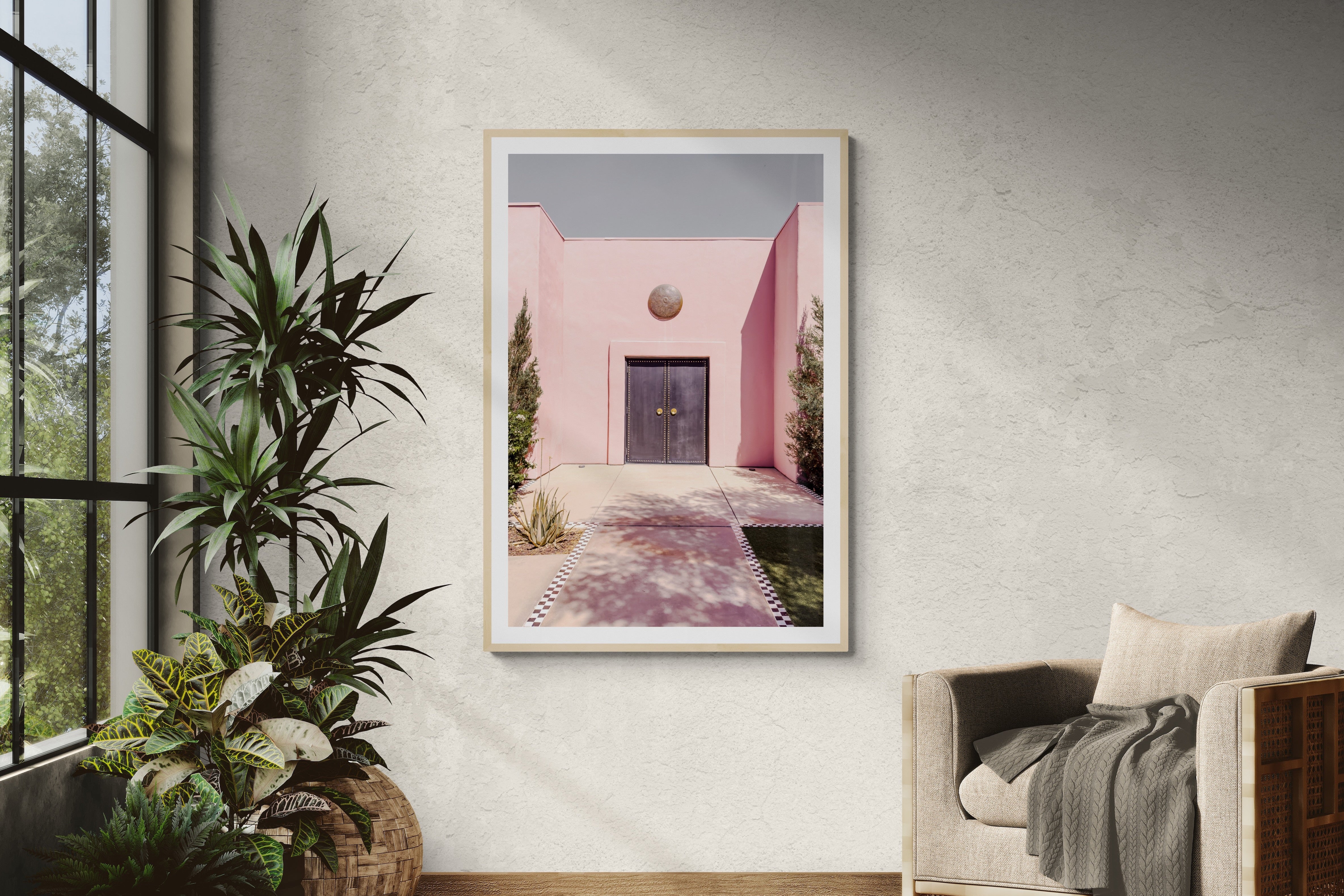 Modern interior with a chair, plants, and a framed picture on the wall.