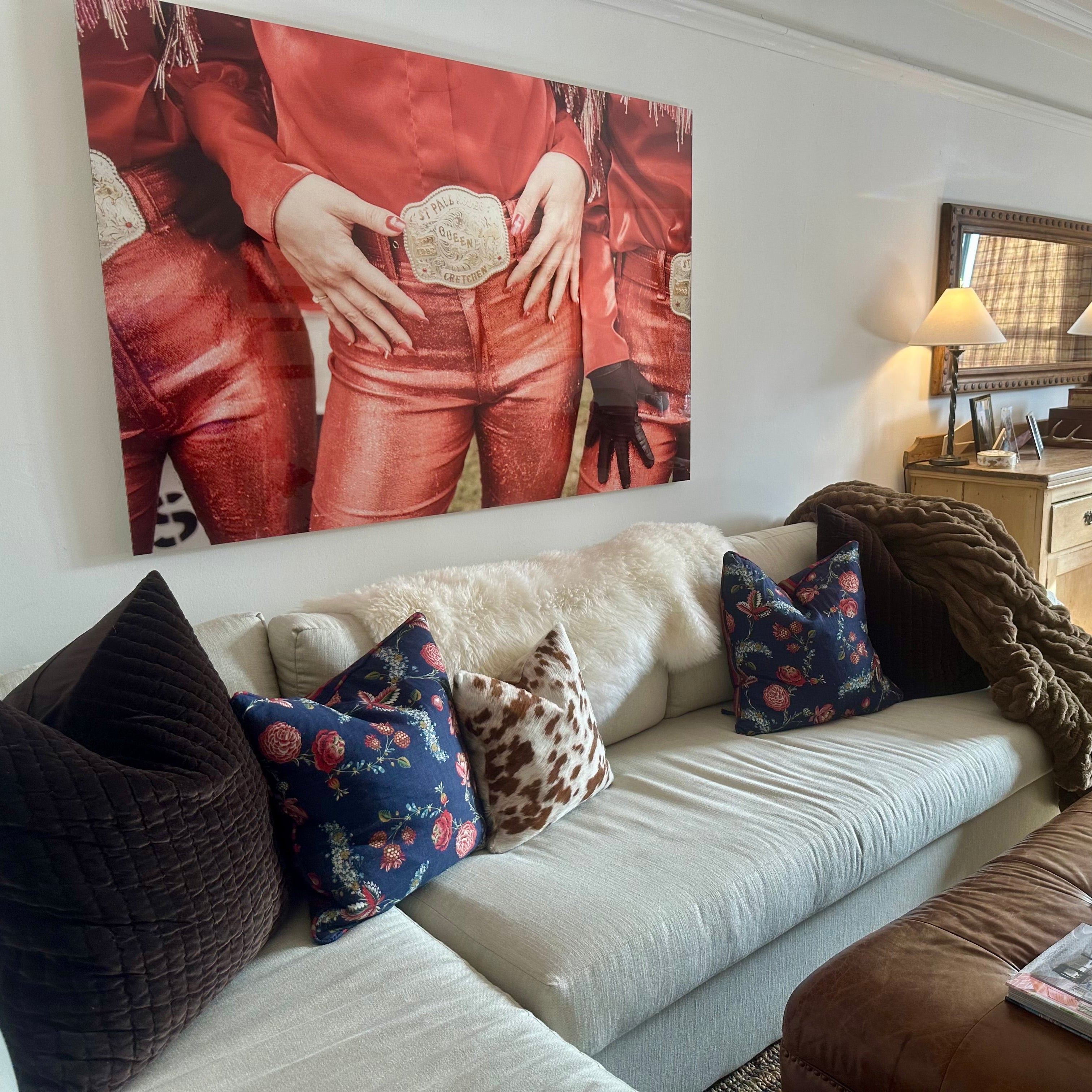 Rodeo Queen print -Living room with a white sofa, brown armchair, and decorative pillows.