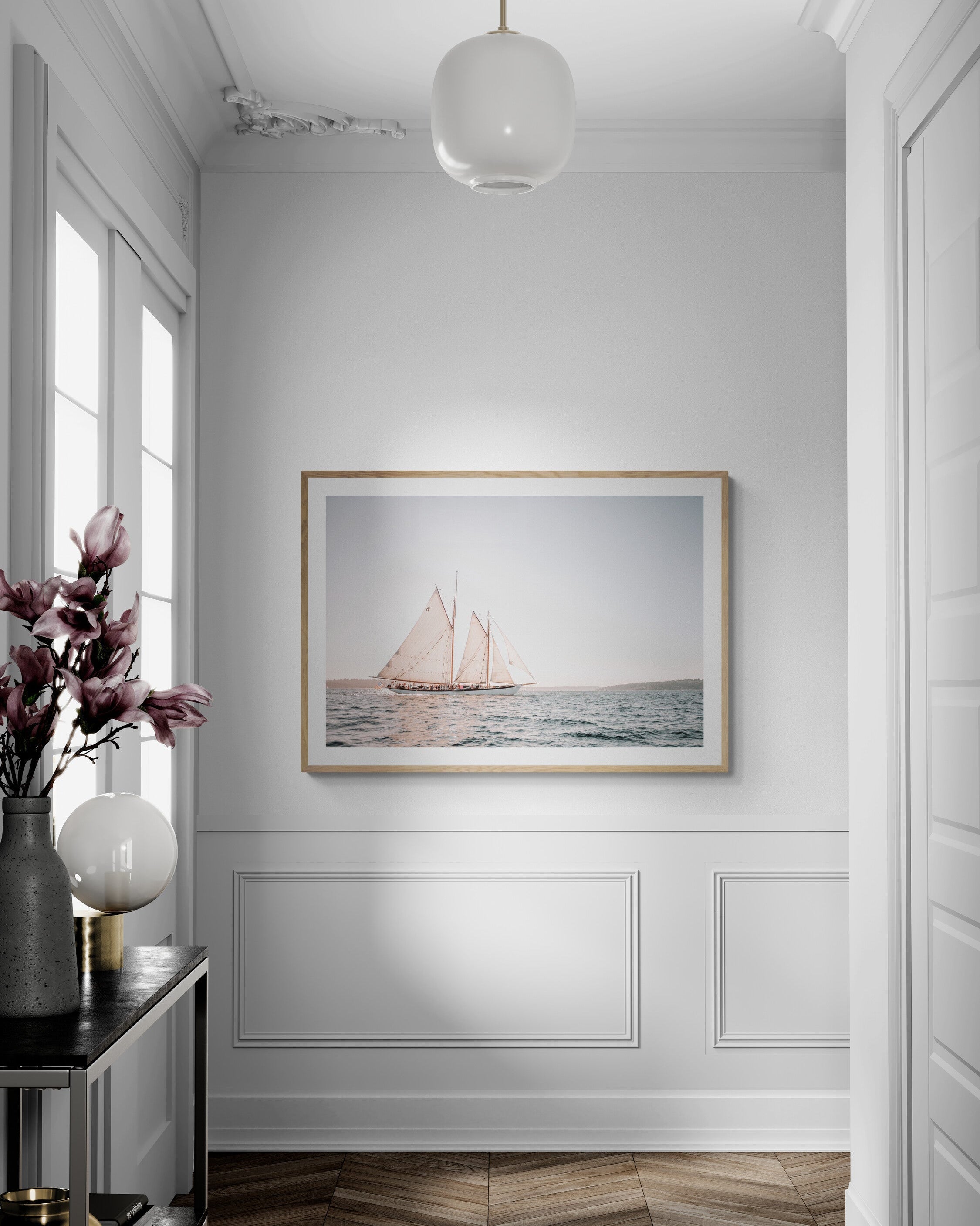 Modern interior with a framed artwork of a sailboat on a white wall.