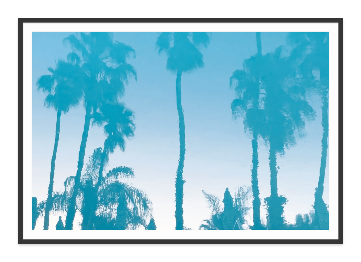 Colony Pool Palms fine art print in a black frame with white mat, by Jules Frazier.