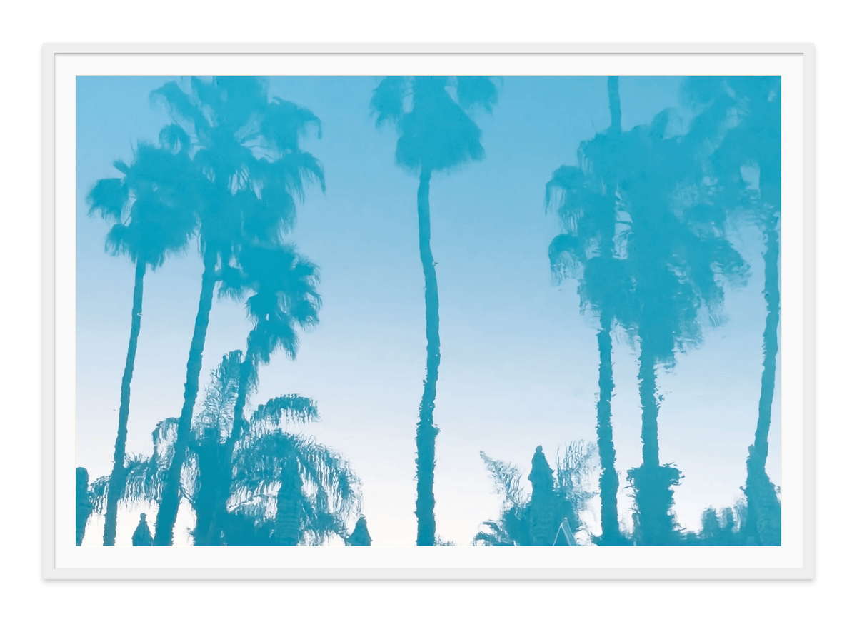 Colony Pool Palms fine art print in a white frame with white mat, by Jules Frazier.